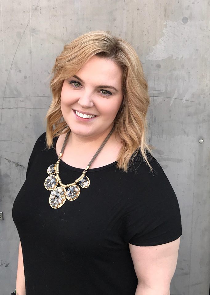 A woman wearing a black shirt and gold necklace.