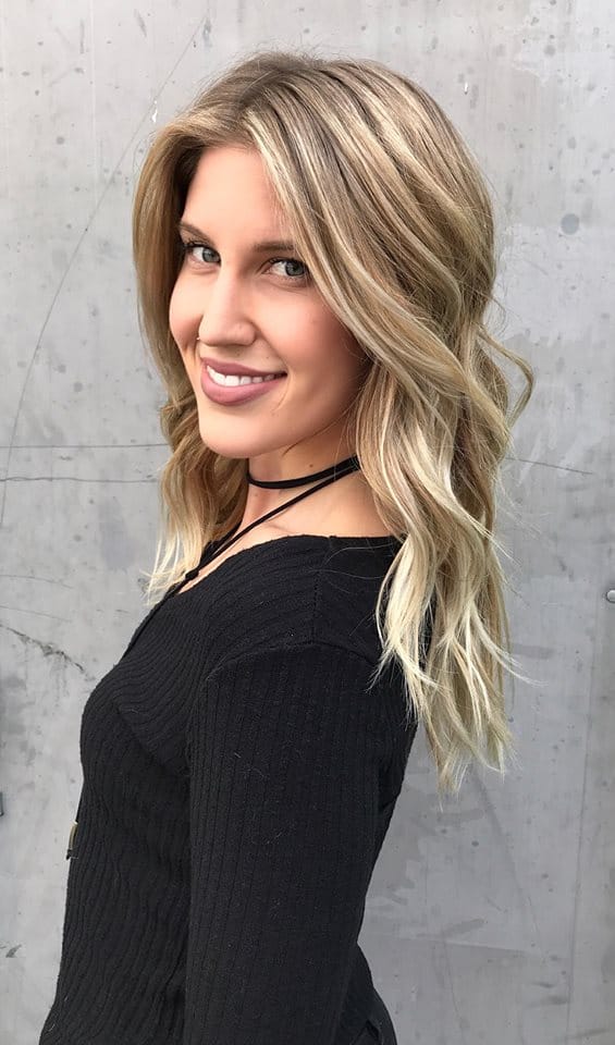 A woman with long blonde hair wearing black.