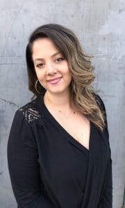 A woman in black shirt smiling for the camera.