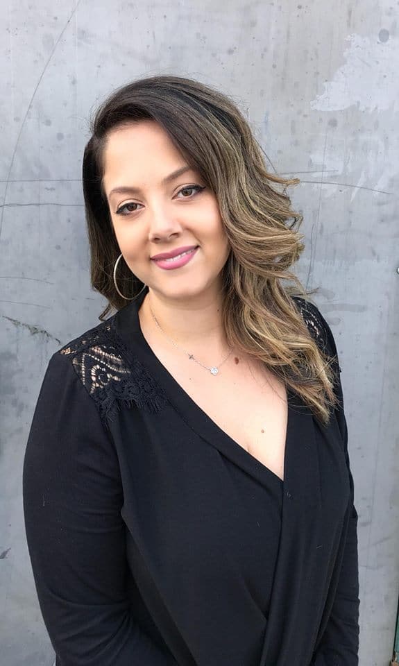 A woman in black shirt smiling for the camera.