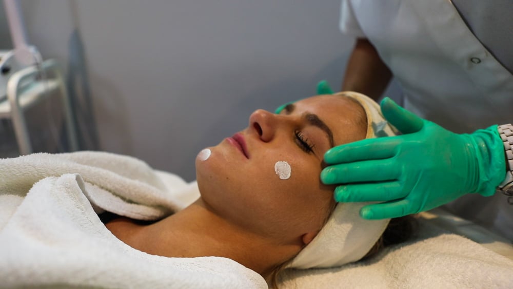 A woman getting her face waxed at the spa