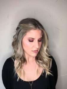 A woman with long blonde hair and brown eyes.