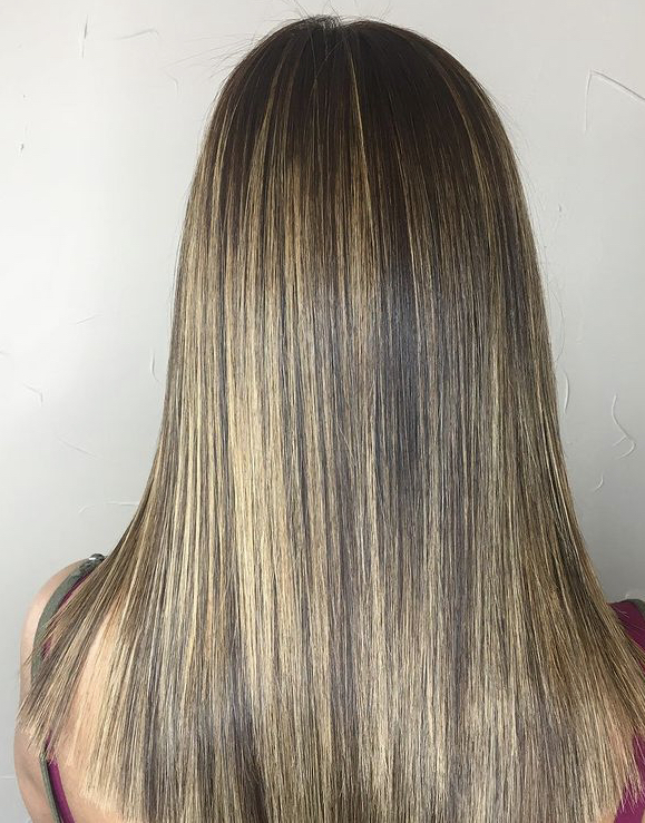 A woman with long hair is looking at the camera.