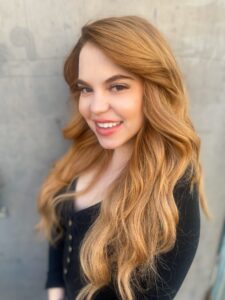 A woman with long blonde hair smiling for the camera.