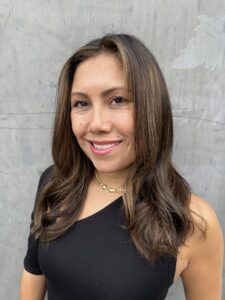 A woman in black shirt smiling for the camera.