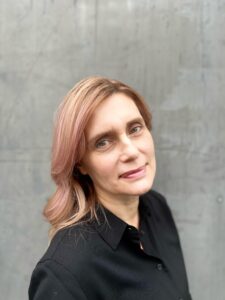 A woman with long hair and wearing black shirt.