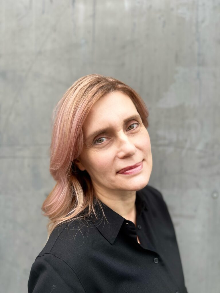 A woman with long hair and wearing black shirt.